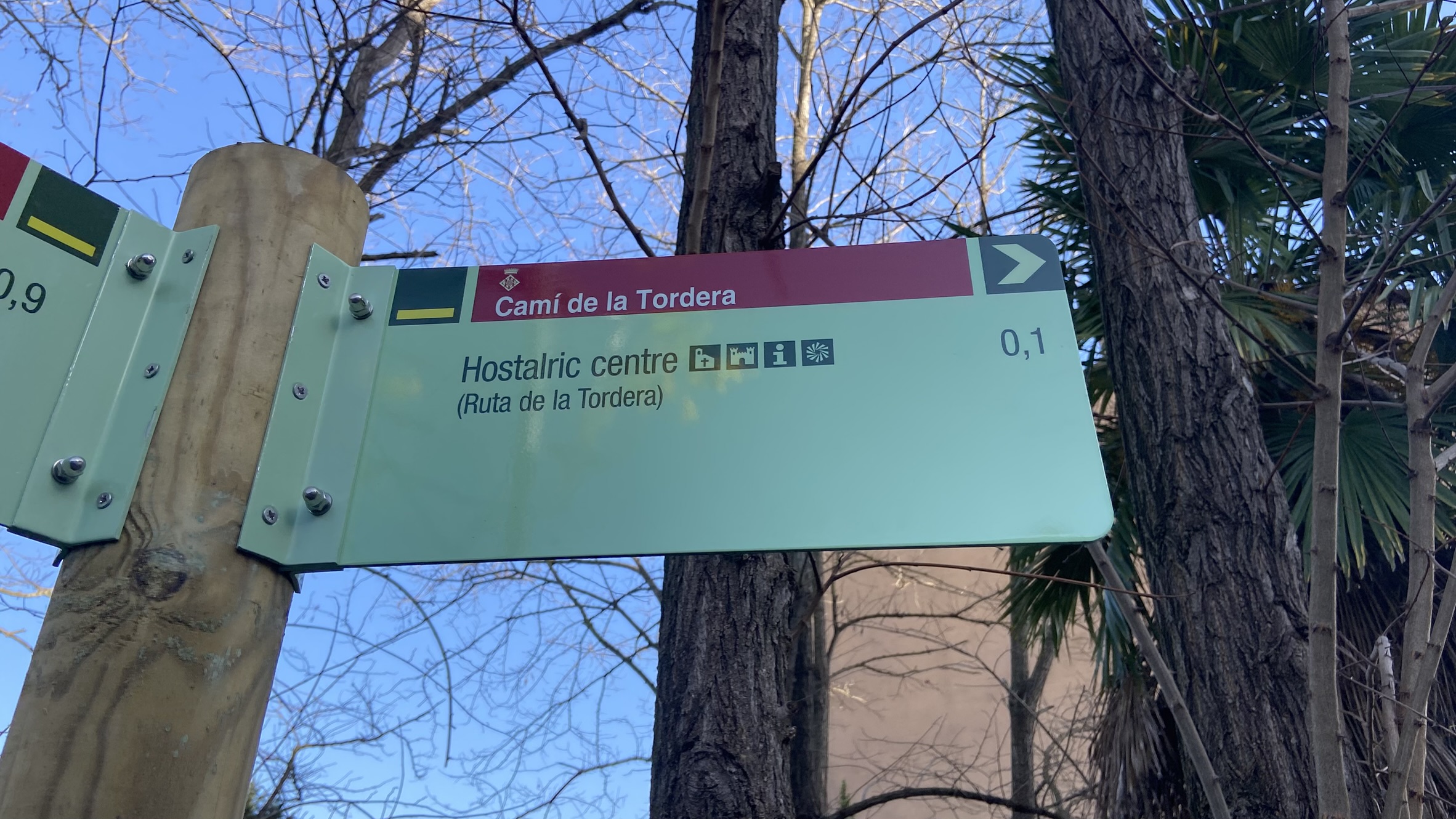 Foto: Tourdera. Senyalització entre l'estació de tren d'Hostalric i la Plaça dels Bous.